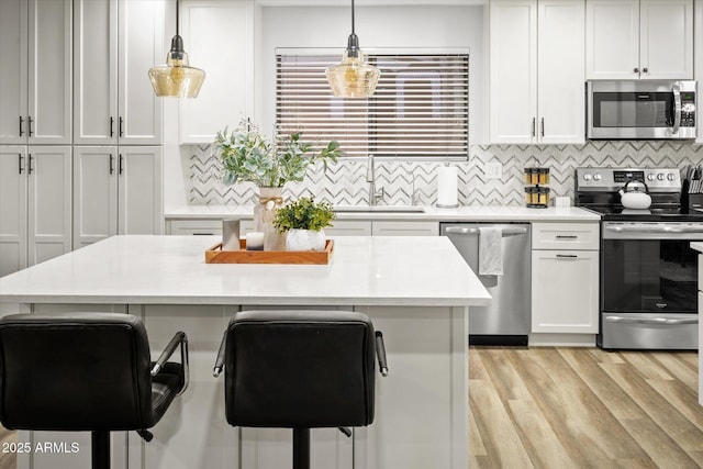 10617 W Daley Ln, Peoria, AZ 85383 - kitchen with stainless steel appliances, a sink, a kitchen breakfast bar, and light countertops