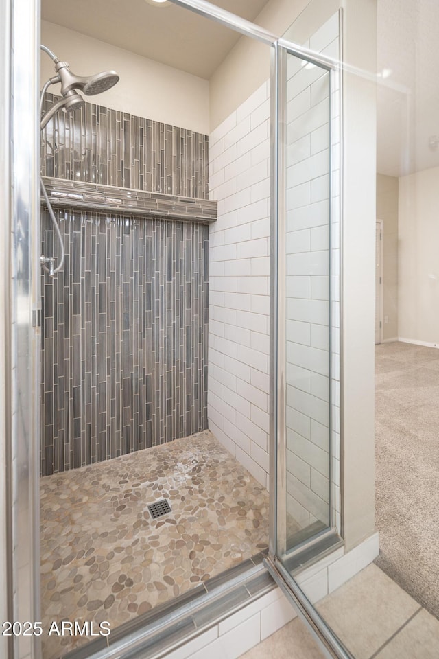 bathroom with tiled shower and tile patterned flooring