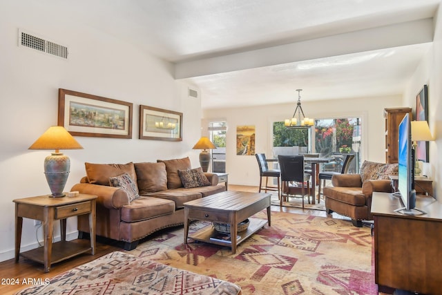 living room with an inviting chandelier and light hardwood / wood-style flooring