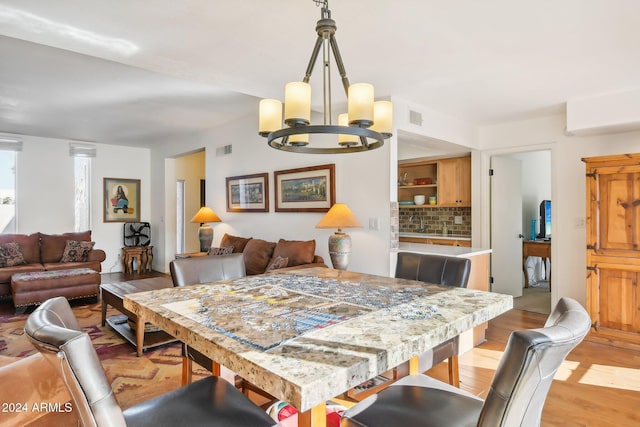 dining space featuring light hardwood / wood-style floors and a chandelier