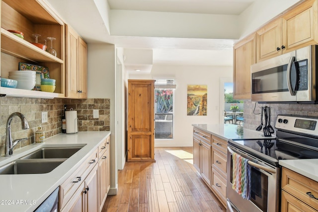 kitchen with tasteful backsplash, appliances with stainless steel finishes, sink, and light brown cabinets