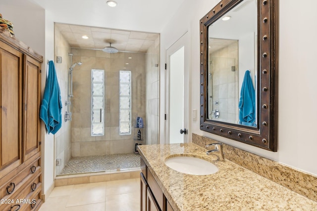 bathroom with an enclosed shower, vanity, and tile patterned flooring