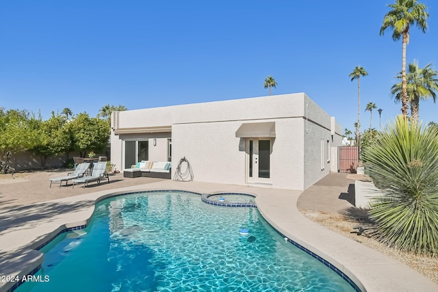 rear view of house with an outdoor living space, a pool with hot tub, and a patio area