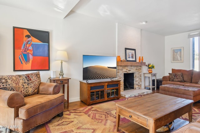 living room featuring a stone fireplace and light hardwood / wood-style floors