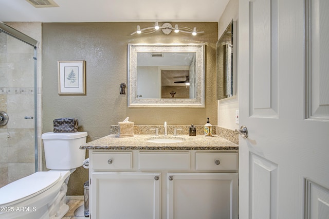 bathroom with vanity, a stall shower, visible vents, and toilet