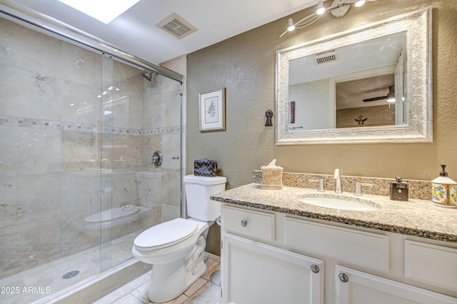 bathroom featuring a textured wall, vanity, toilet, a shower stall, and visible vents
