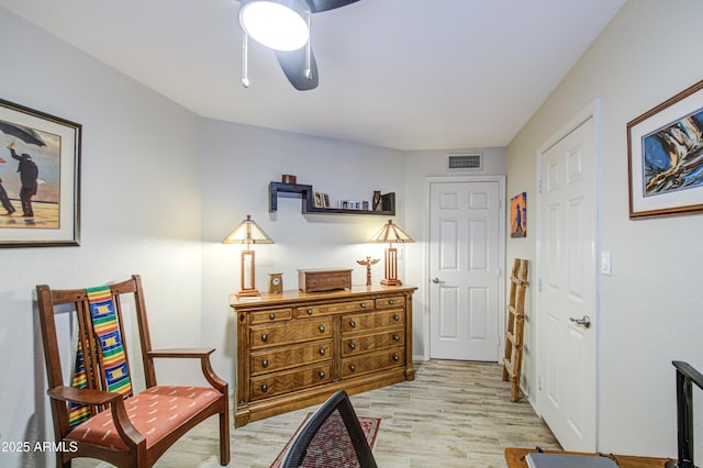 living area featuring light wood-type flooring and visible vents