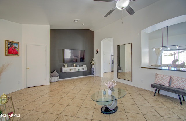 tiled living room featuring ceiling fan and high vaulted ceiling