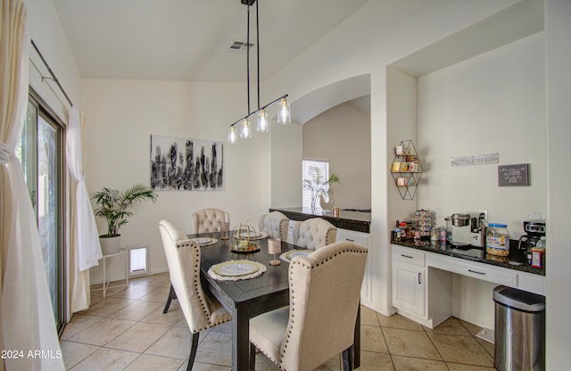 dining room with lofted ceiling, light tile patterned flooring, and a wealth of natural light