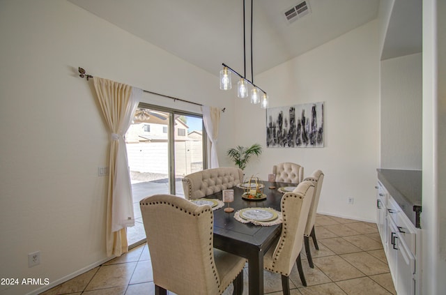 dining space featuring vaulted ceiling and light tile patterned floors