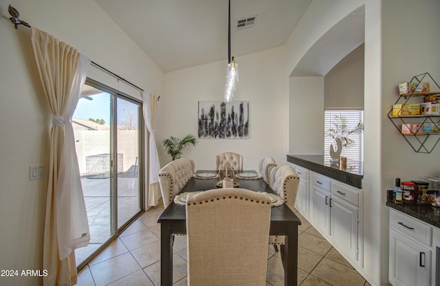 dining space featuring lofted ceiling and light tile patterned flooring