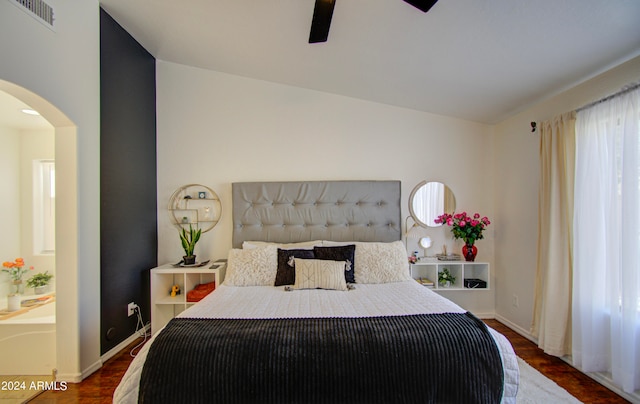 bedroom with dark hardwood / wood-style flooring, lofted ceiling, multiple windows, and ceiling fan