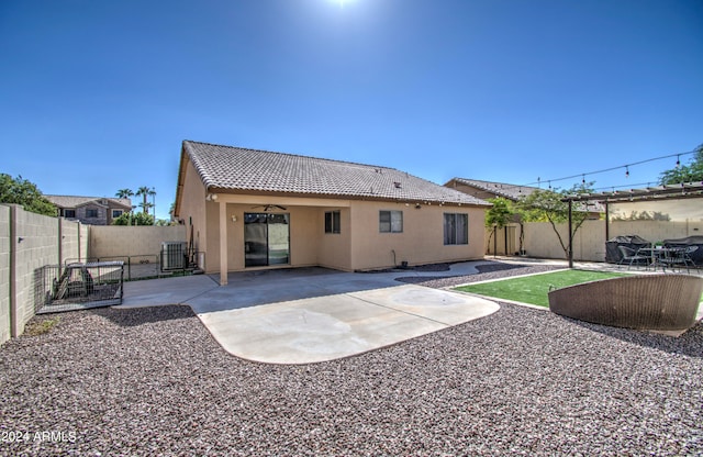 rear view of house with a patio area and central AC