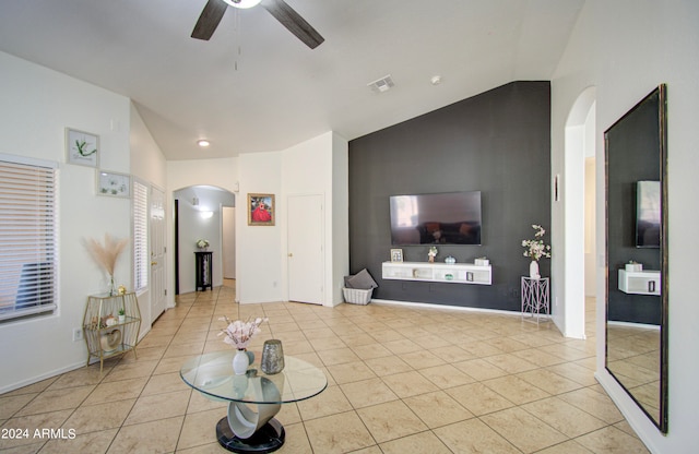 tiled living room with ceiling fan and lofted ceiling