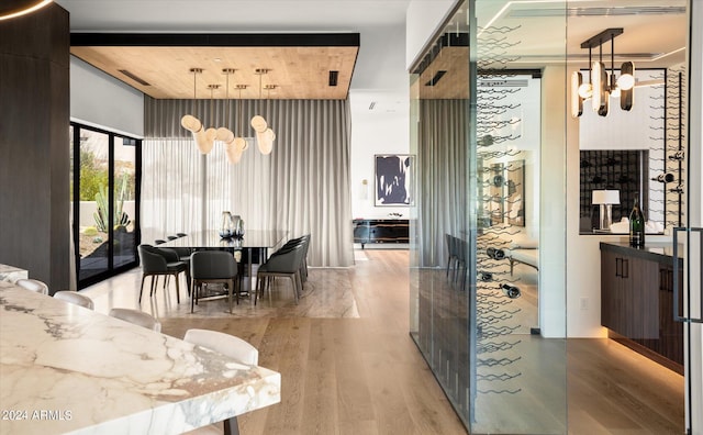 interior space featuring pendant lighting, light stone countertops, light hardwood / wood-style flooring, and wood ceiling