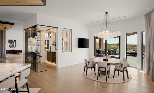 dining area featuring light hardwood / wood-style flooring and an inviting chandelier