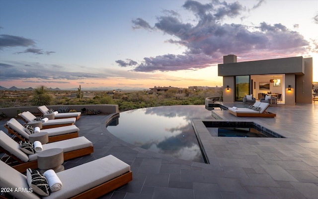 pool at dusk featuring a patio