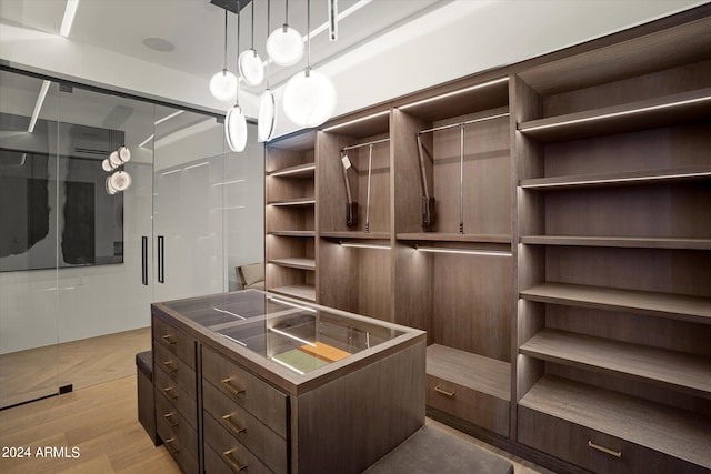 walk in closet with light wood-type flooring