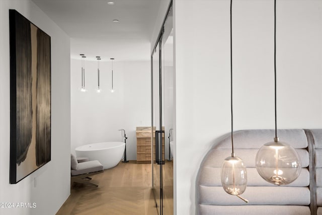 bathroom featuring parquet floors and a tub