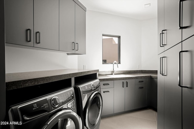 washroom featuring washer and dryer, cabinets, light tile flooring, and sink