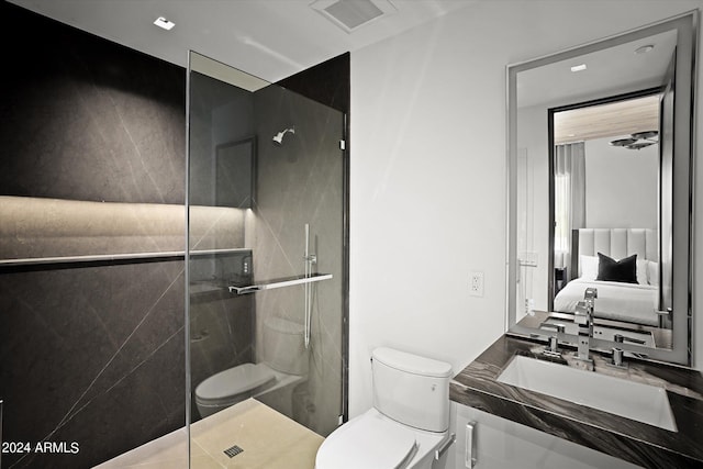 bathroom with toilet, vanity, and a shower with shower door