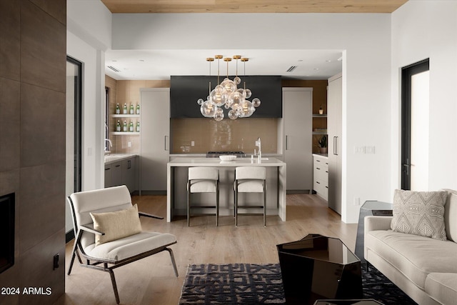 living room with light hardwood / wood-style flooring, sink, and a chandelier