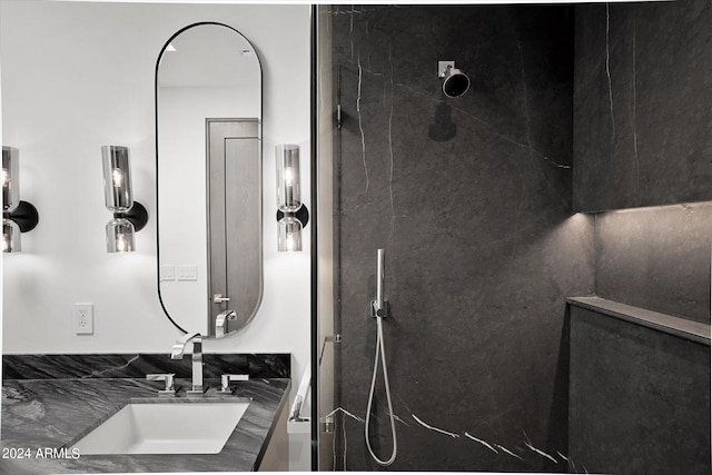 bathroom with backsplash, tiled shower, and vanity with extensive cabinet space