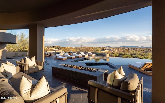 balcony with a hot tub, an outdoor living space, and a patio