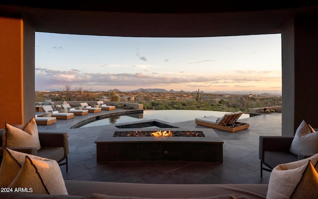 patio terrace at dusk with an outdoor living space with a fire pit