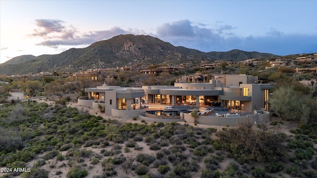 back house at dusk with a balcony and a mountain view