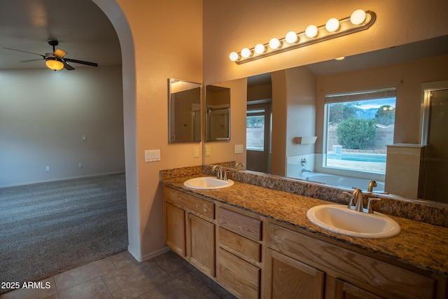 bathroom with a sink, a bath, a ceiling fan, and tile patterned flooring