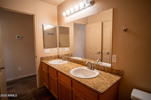 bathroom with wood finished floors, baseboards, and a sink