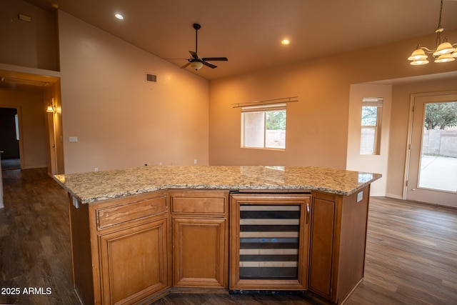 kitchen featuring beverage cooler, visible vents, plenty of natural light, and ceiling fan with notable chandelier