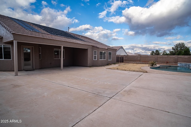 rear view of house with a patio area, a fenced in pool, a fenced backyard, and stucco siding