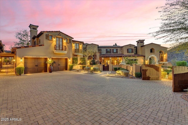 10935 E Grandview Way, Scottsdale, AZ 85255 - mediterranean / spanish-style home featuring decorative driveway, a chimney, an attached garage, and fence