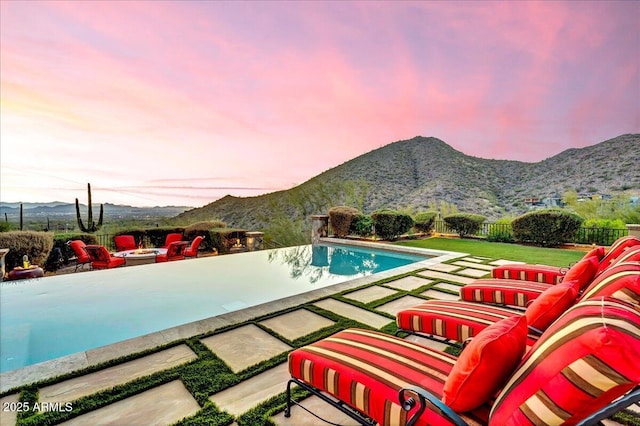 10935 E Grandview Way, Scottsdale, AZ 85255 - pool at dusk featuring a fire pit, a patio area, and a mountain view