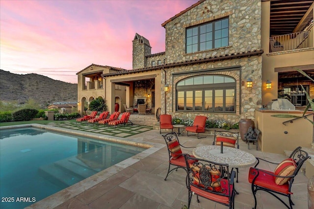 10935 E Grandview Way, Scottsdale, AZ 85255 - rear view of house featuring stone siding, a patio area, a balcony, and an outdoor pool
