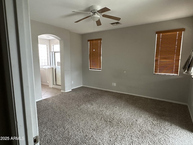 carpeted spare room featuring ceiling fan