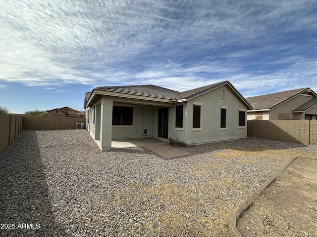 back of property with central AC and a patio area