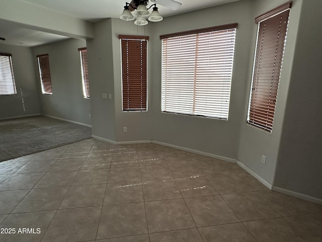 tiled spare room featuring ceiling fan