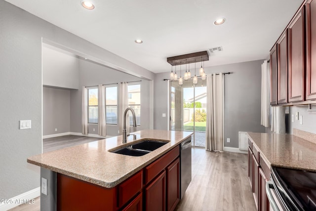 kitchen with stainless steel dishwasher, a kitchen island with sink, sink, and a wealth of natural light