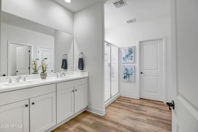 19736 W Turney Ave, Litchfield Park, AZ 85340 - bathroom with wood finished floors, a shower stall, double vanity, and baseboards