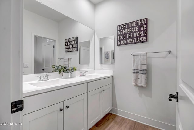 19736 W Turney Ave, Litchfield Park, AZ 85340 - bathroom featuring wood finished floors, double vanity, and baseboards
