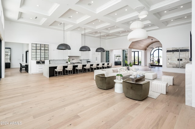 living room with coffered ceiling, beamed ceiling, and light hardwood / wood-style floors