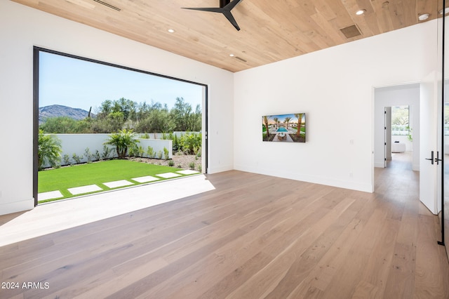 spare room featuring wood ceiling, ceiling fan, light hardwood / wood-style flooring, and a mountain view