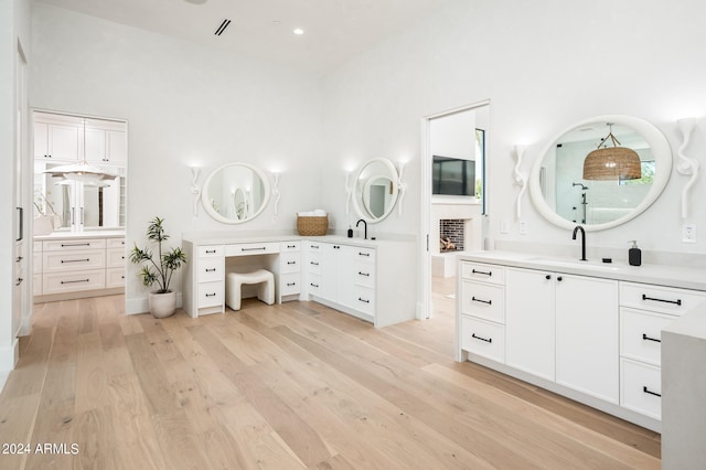 bathroom with wood-type flooring, a high ceiling, and vanity