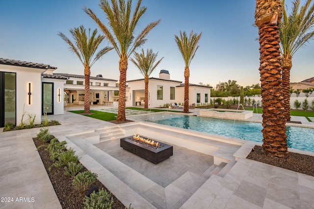 view of swimming pool with an in ground hot tub, a patio, and an outdoor fire pit