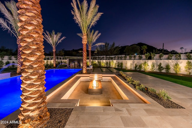 view of swimming pool with pool water feature, a patio, and an outdoor fire pit