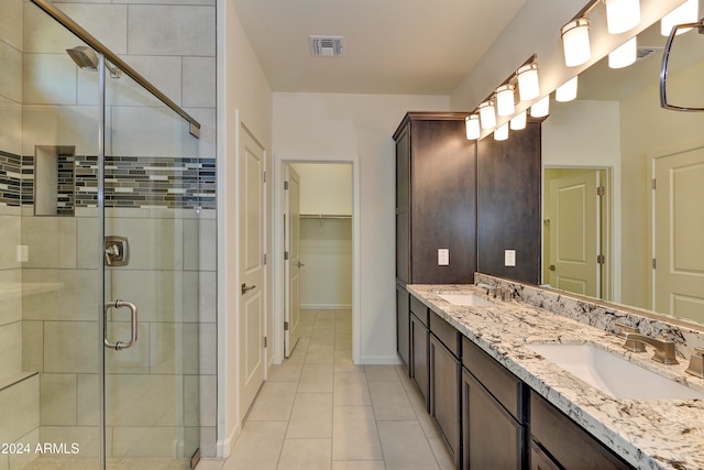 bathroom with tile patterned floors, vanity, and a shower with shower door