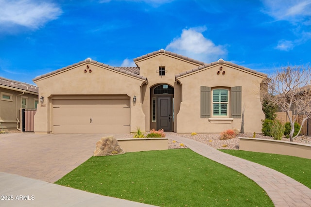 mediterranean / spanish home featuring a tile roof, an attached garage, decorative driveway, a front lawn, and stucco siding